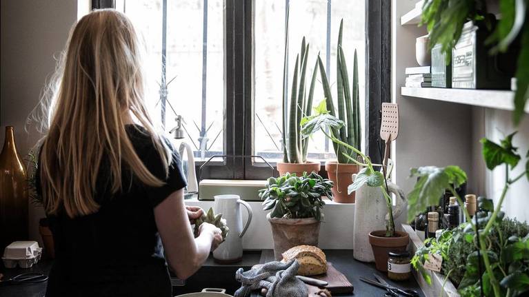 Woman cooking in SieMatic kitchen with herb garden